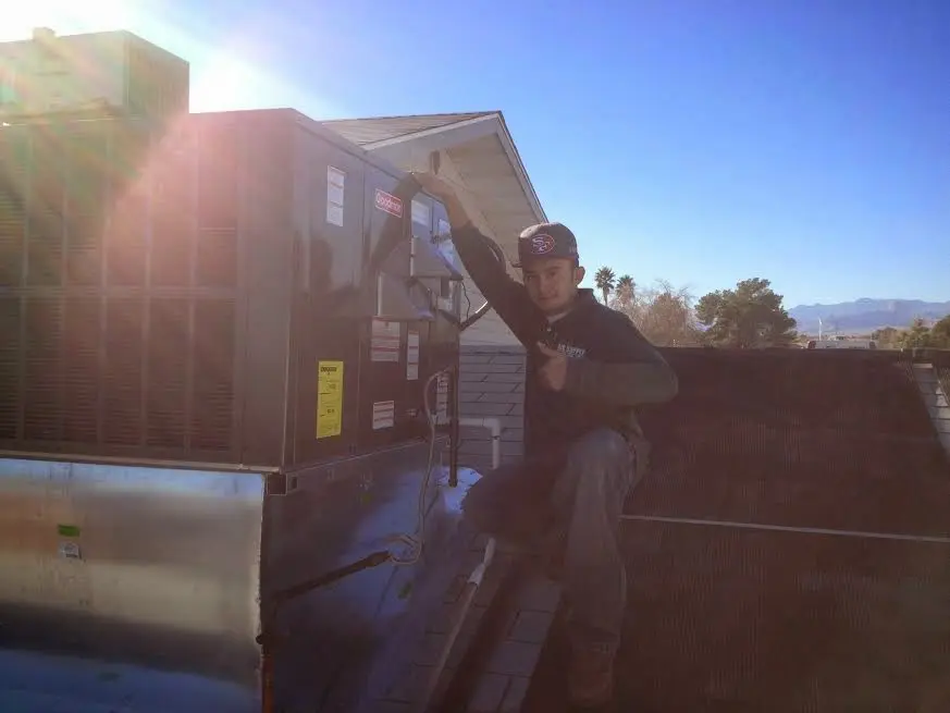 HVAC technician performing AC Tune-Up on a rooftop unit in Cheverly