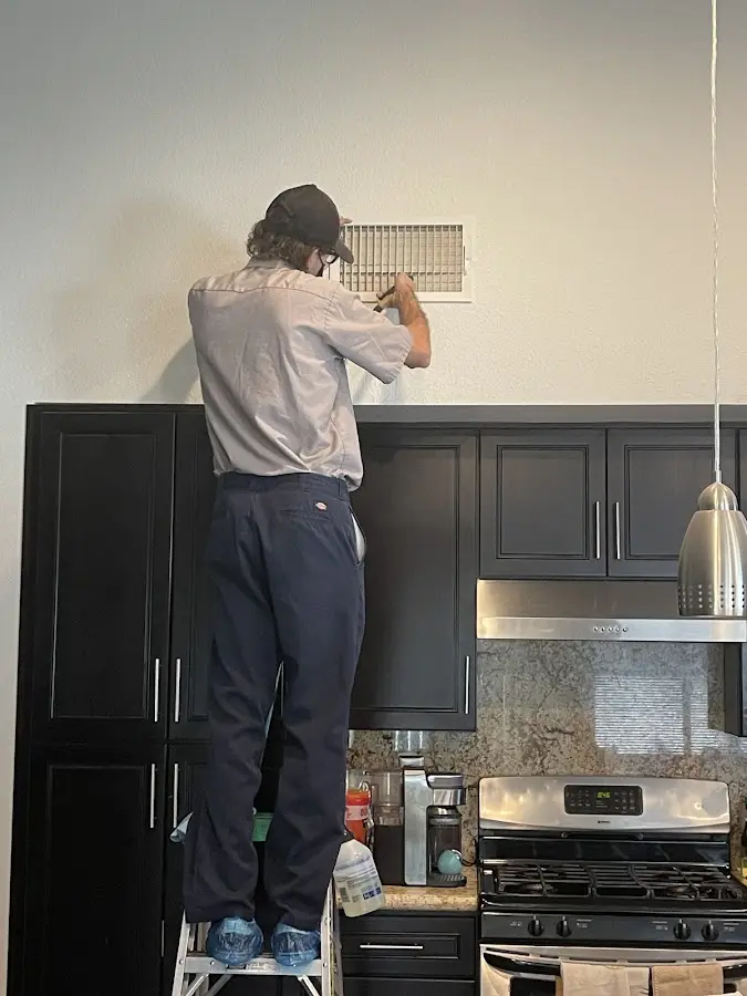 Technician inspecting an air vent during HVAC service in Cheverly